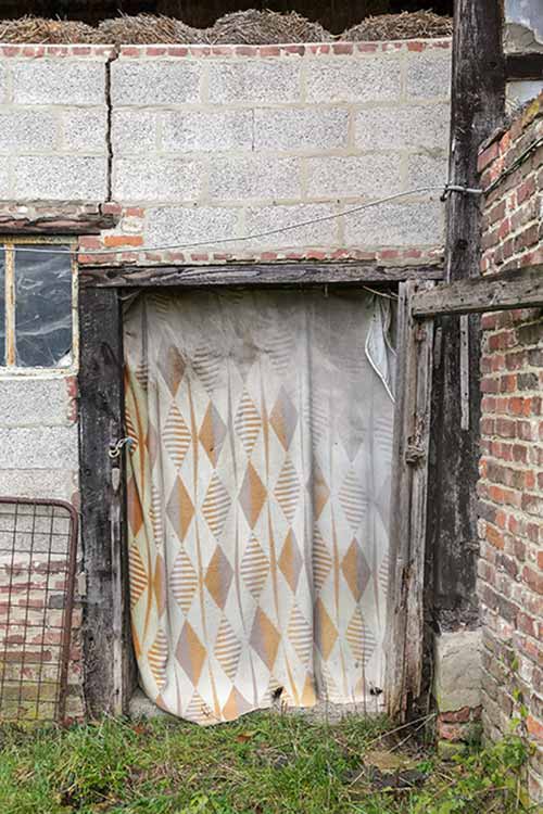 An abandoned house with a curtain in the doorway