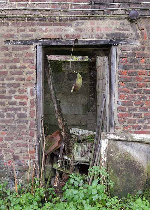 A soup ladle hanging by the door of an abandoned house