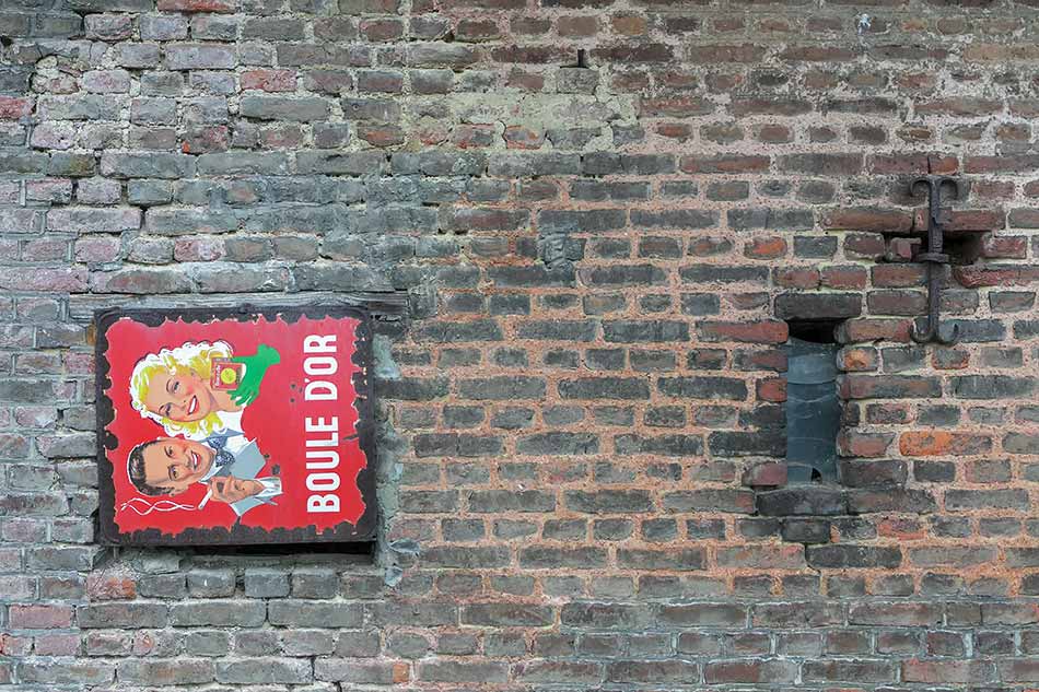 A window boarded up with a Boule d'Or advertising sign