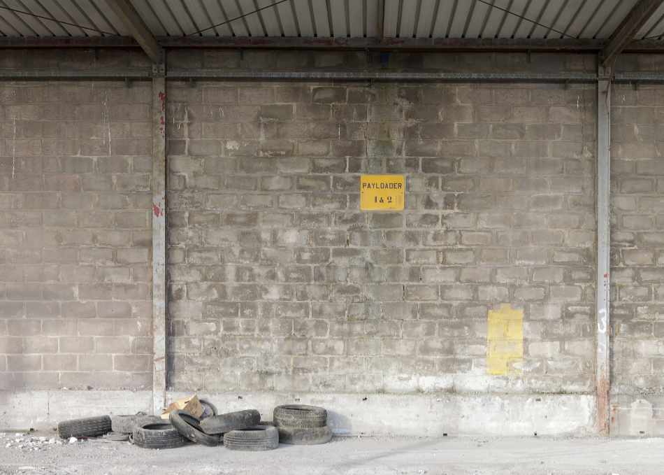 An empty payloader parking lot with a pile of tires