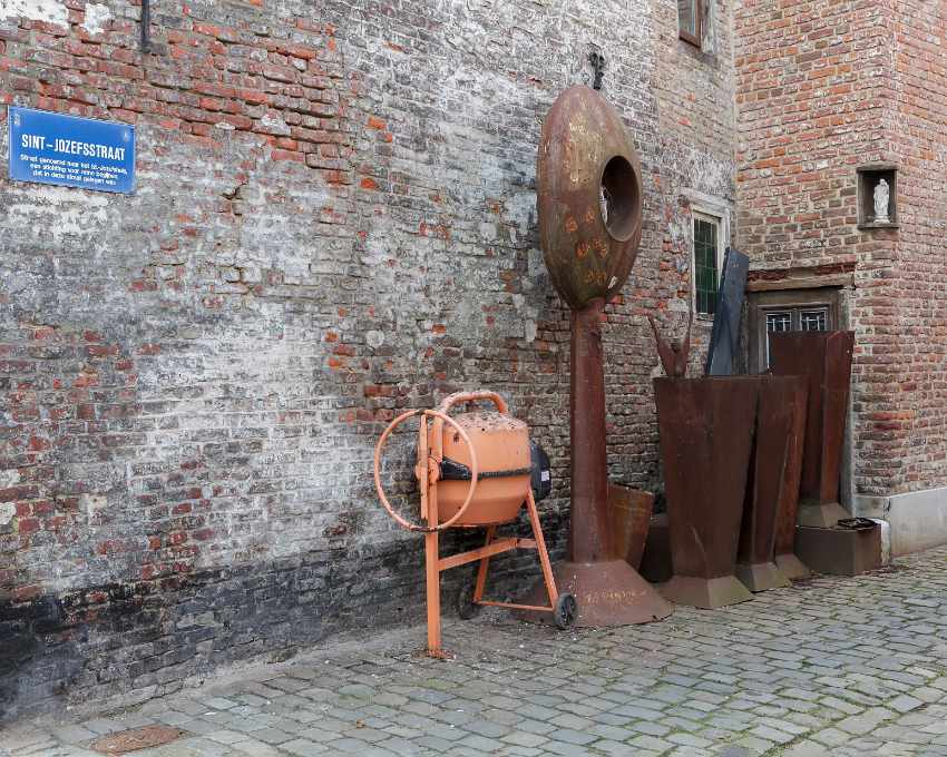 A row of rusty artworks and a cement mixer