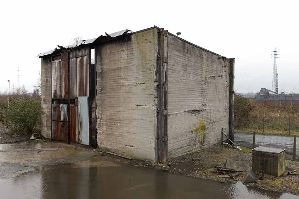 A dilapidated industrial storage space after a rain shower