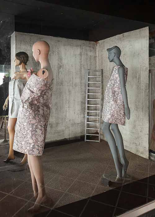 Mannequins and a stairway in a closed clothing store