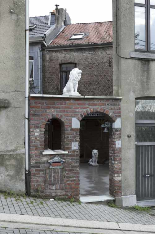 Two statues of a lion at the entrance to a house.