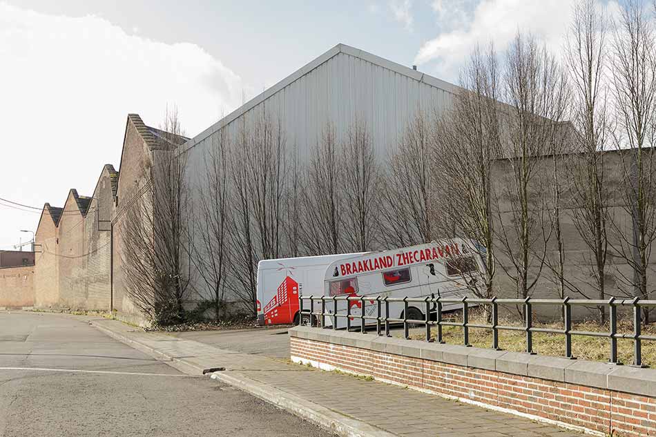 A caravan in a parking lot in an industrial area