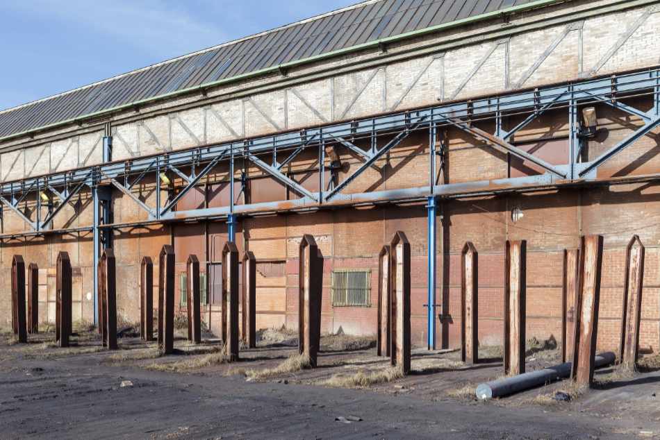 A row of metal poles lined up at a factory hall