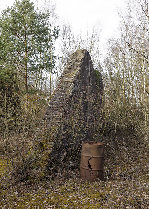 The remains of a former blast furnace with a rusty oil drum