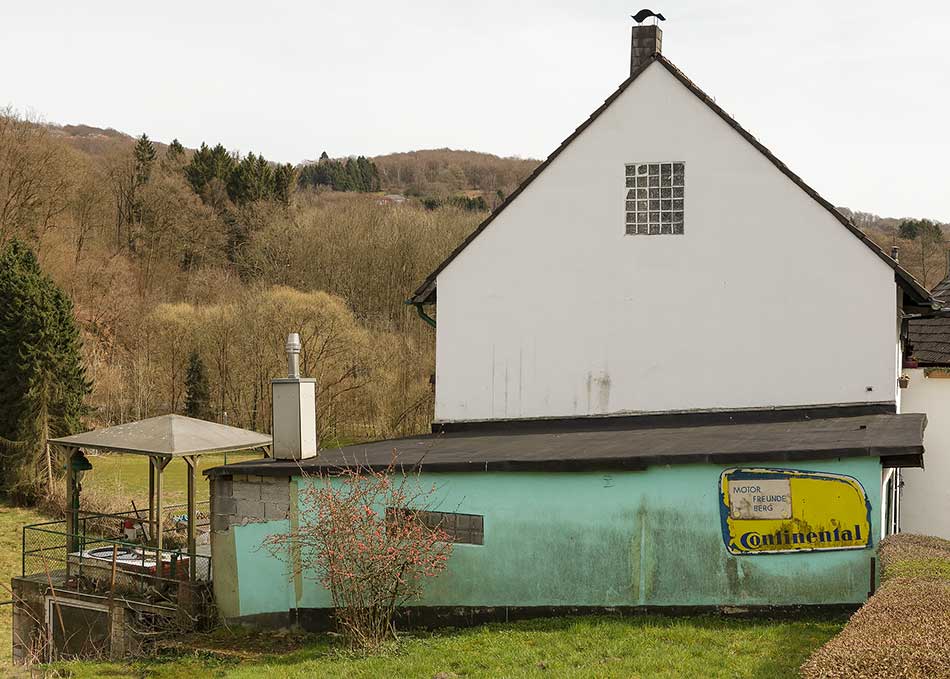 A "Continental" advertisement for "Motor Freunde" on the wall of a farmhouse