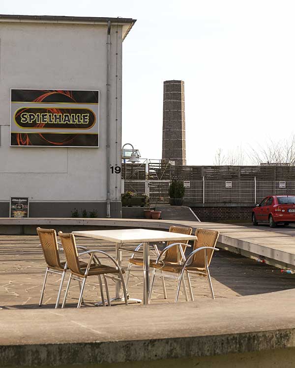 An empty cafe terrace in front of an arcade