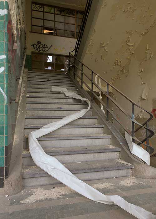 An unrolled fire hose in an abandoned stairwell